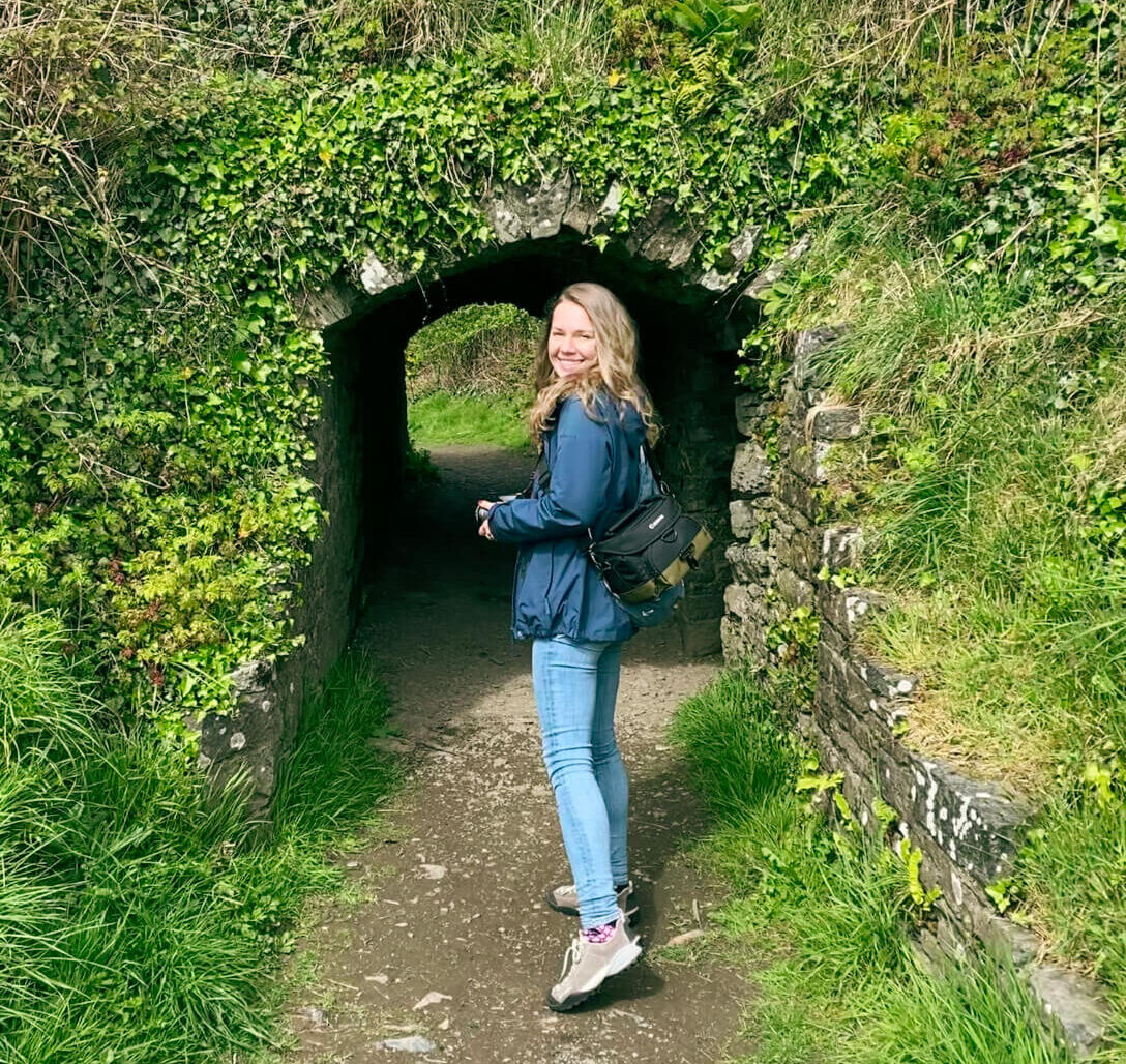 Travel like local Autorin in Irland vor einem bewachsenen Tunnel